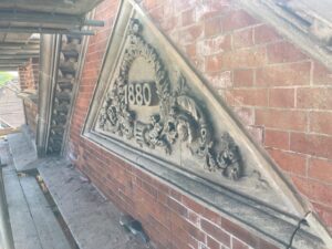 Photo of the brickwork and stonework at a high level of Ashbourne Methodist Church which is being cleaned and repointed